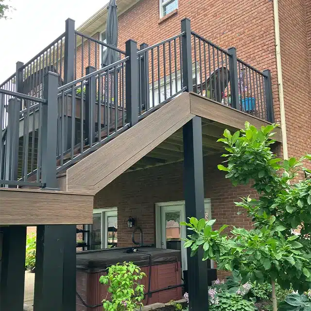 backyard deck with stained wood composite boards and black railing