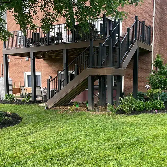 wide photo of backyard deck with composite wood boards and black railing