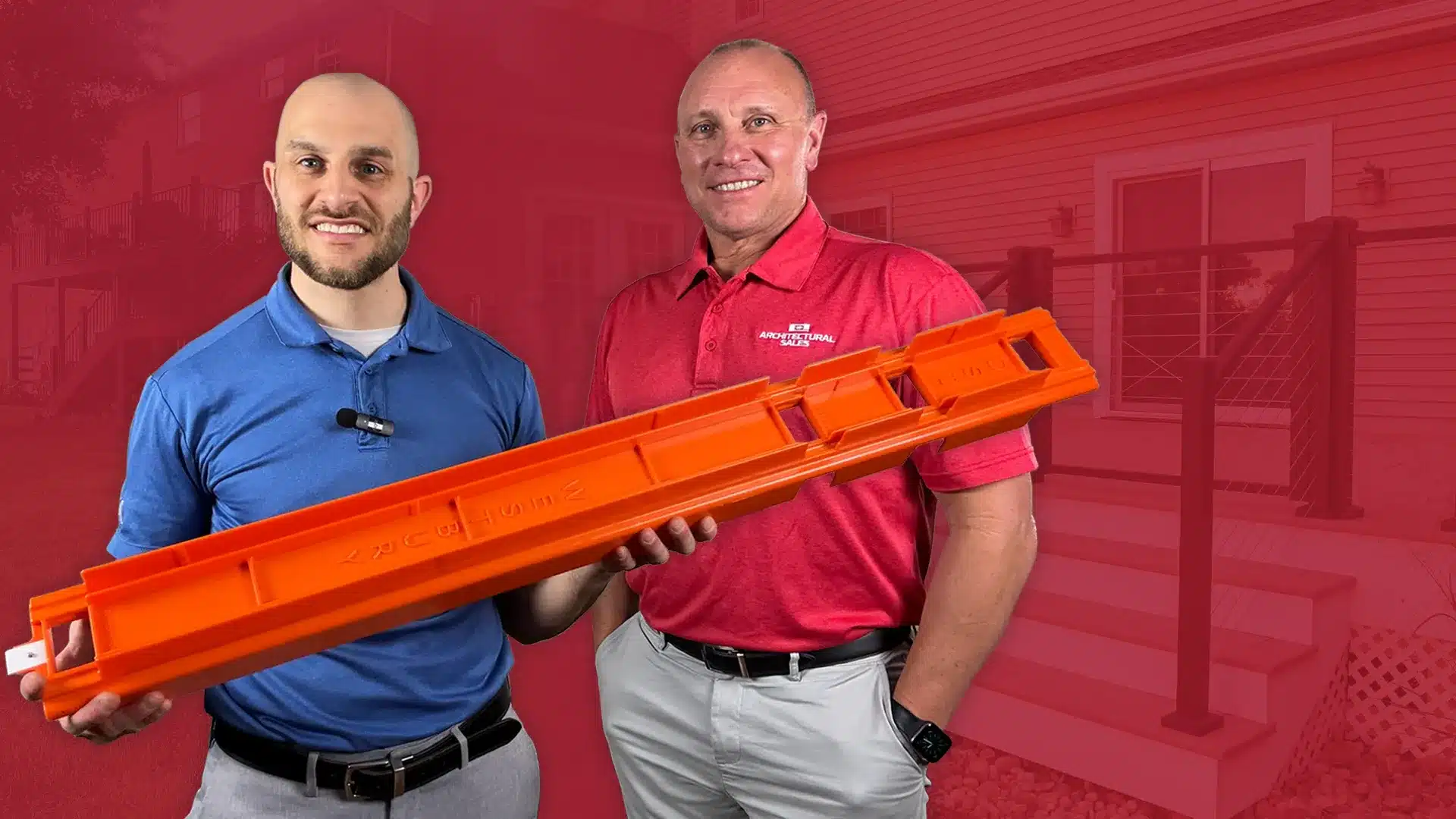 two adult men in business professional attire holding an tall orange railing guide tool