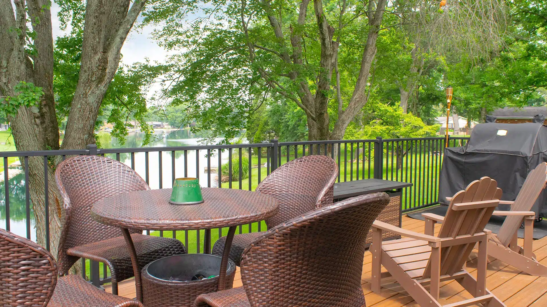 backyard deck with black railing overlooking a lake